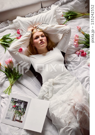 Relaxed woman enjoying peaceful morning rest, Serene woman lying with tulips and soft sunlight Relaxed woman enjoying peaceful morning rest, Serene woman lying with tulips and soft sunlight 135242552