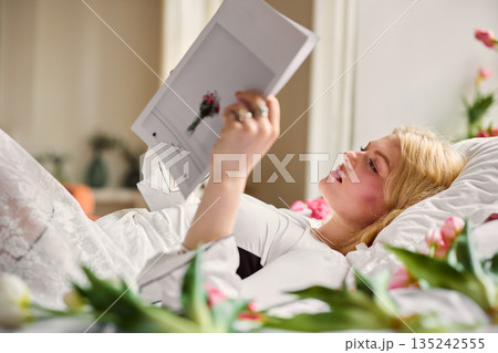 Serene lady enjoying peaceful sunrise moment, Tranquil female in bed with blooming tulips at dawn Serene lady enjoying peaceful sunrise moment, Tranquil female in bed with blooming tulips at dawn 135242555