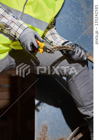 white construction tradesman cutting metal with grinder 135242585