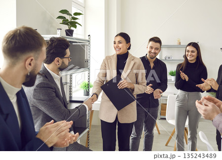 Friendly female manager shakes hands with her male colleague, congratulating him on job well done. Friendly female manager shakes hands with her male colleague, congratulating him on job well done. 135243489