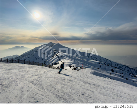 Man snowboarding on mountain slope at Amirsoy ski resort. Winter sport activity Man snowboarding on mountain slope at Amirsoy ski resort. Winter sport activity 135243519