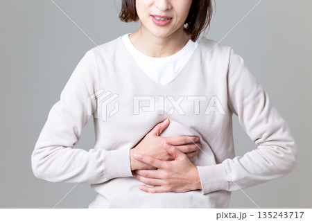 お腹を押さえて腹痛に苦しむミドル女性 お腹を押さえて腹痛に苦しむミドル女性 135243717