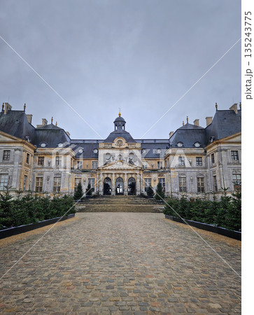 Maincy, France - December 11, 2025: Grand facade of Chateau de Vaux-le-Vicomte with cobblestone courtyard. Beautiful Baroque architecture decorated with small evergreen trees for the winter holidays Maincy, France - December 11, 2025: Grand facade of Chateau de Vaux-le-Vicomte with cobblestone courtyard. Beautiful Baroque architecture decorated with small evergreen trees for the winter holidays 135243775