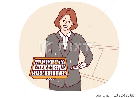 Woman jewelry store clerk demonstrates collection of earrings with precious stones, offering to buy 135245369