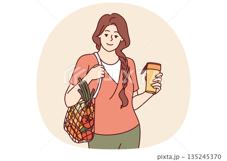 Woman with mesh bag filled with vegetables, drinks coffee from reusable cup to take care of ecology Woman with mesh bag filled with vegetables, drinks coffee from reusable cup to take care of ecology 135245370