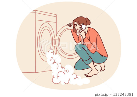 Woman near broken washing machine calls home electronics repairman because of foam pouring out drum Woman near broken washing machine calls home electronics repairman because of foam pouring out drum 135245381