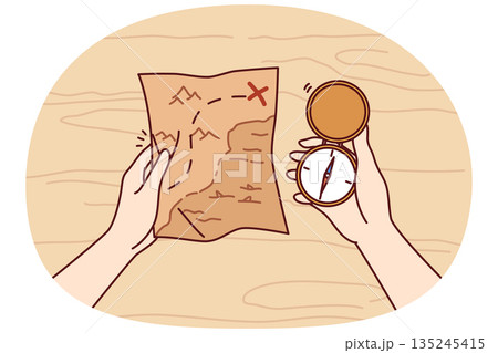Treasure map and compass in hands of man looking for expensive jewels lost at sea from pirate ships 135245415