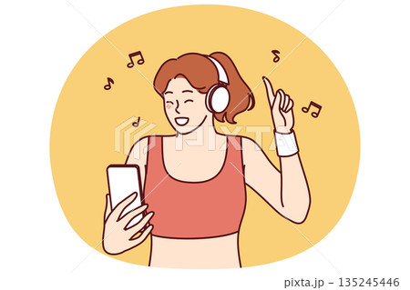 Woman fitness trainer in headphones listens to music using mobile phone to manage playlist Woman fitness trainer in headphones listens to music using mobile phone to manage playlist 135245446
