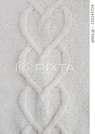 White cable knit sweater texture close up showing cozy warmth and soft fabric Demonstrating Pantone color of the year 2026 - Cloud Dancer. White cable knit sweater texture close up showing cozy warmth and soft fabric Demonstrating Pantone color of the year 2026 - Cloud Dancer. 135245724