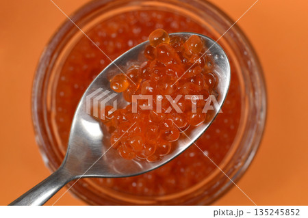 Red trout caviar on a silver spoon 135245852