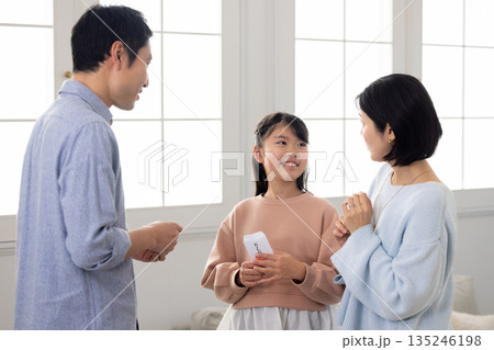 男性からお年玉をもらう小学生の女の子 135246198