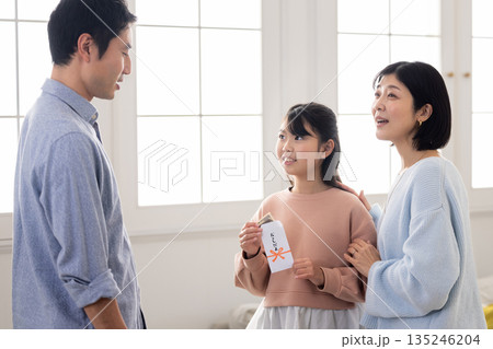 お年玉の中身を確認して微笑む小学生の女の子 135246204