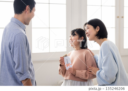 お年玉の中身を確認して微笑む小学生の女の子 お年玉の中身を確認して微笑む小学生の女の子 135246206