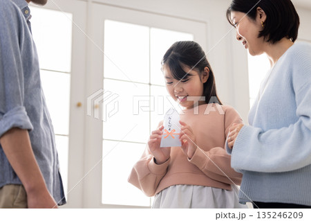 お年玉の中身を確認して微笑む小学生の女の子 135246209