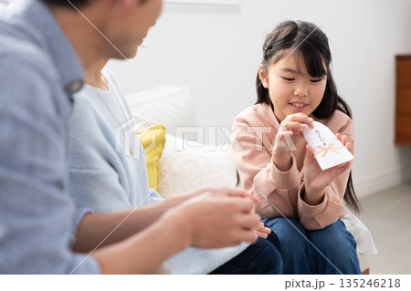 お年玉の中身を確認して微笑む小学生の女の子 135246218