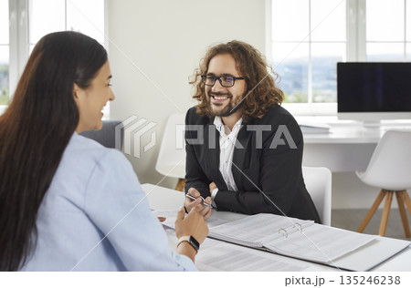 Business people at work in office. Two employers sitting at the desk on workplace and talking. 135246238