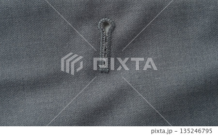 Grey textile material with button hole Grey textile material with button hole 135246795