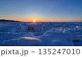 流氷原に沈む夕日と黄金色の冬空 135247010