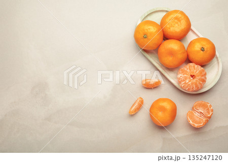 Fresh small tangerine mandarin orange in plate on light background. 135247120