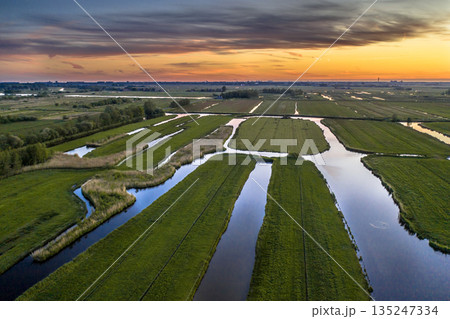 Sunset over canal in Historic dutch landscape 135247334