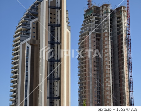 construction with towers and sky, building structures showing finished and active construction 135247819