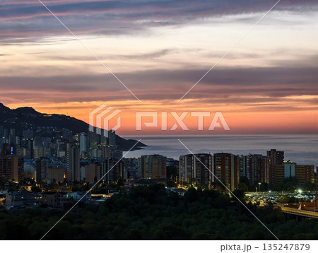 evening horizon with silhouettes, serene evening seaside scene featuring glowing sky and distant 135247879