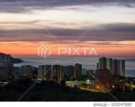 sunny seaside scene, idyllic coastal environment captured at sunset with luminous city and harbor 135247880