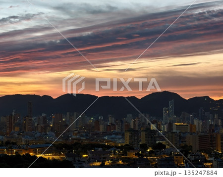 sunset hues blend with towering city silhouettes, twilight colors streak across sky with urban sunset hues blend with towering city silhouettes, twilight colors streak across sky with urban 135247884