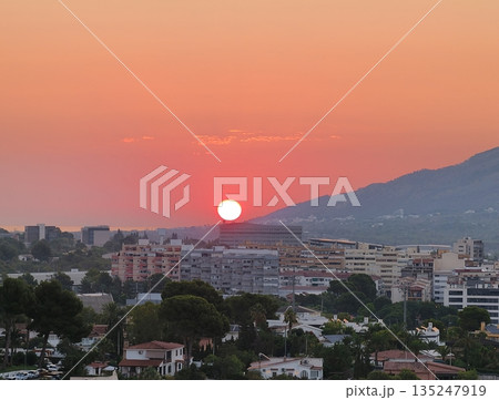 Peaceful horizon with sunset illuminating city and seaside 135247919