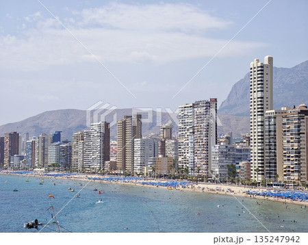 Active seaside setting featuring tourists enjoying sunny weather 135247942