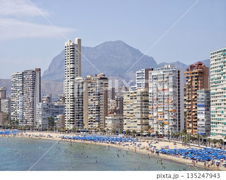 Bustling coastal scene, Active seaside with sunbathers 135247943