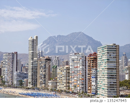 Modern skyscrapers along peaceful blue ocean shore with scenic Modern skyscrapers along peaceful blue ocean shore with scenic 135247945