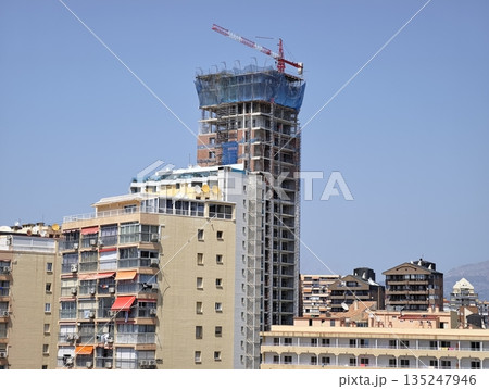 Skyline features rising crane amidst ongoing urban development Skyline features rising crane amidst ongoing urban development 135247946