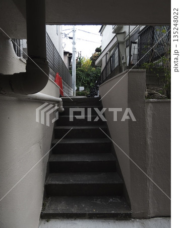 都会の建物の隙間にひっそりと佇むコンクリートの階段坂。静寂な路地へと続く、隠れ家のような日常風景。 135248022