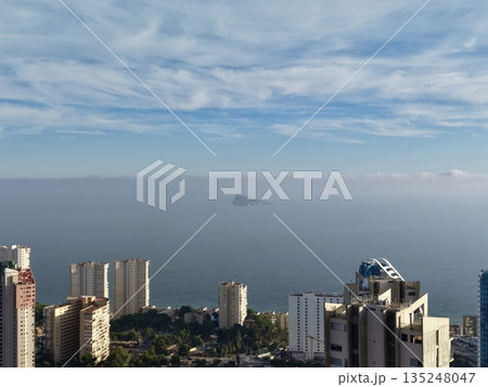 skyline overlooking sea and islands, serene view of waterfront city with distant island and morning sky 135248047
