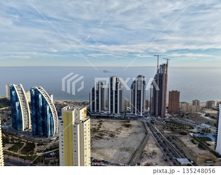 building development near ocean shore, urban project with heavy equipment overlooking ocean horizon 135248056