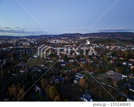 serene aerial perspective capturing church spire amidst softly illuminated townscape at dusk 135248083