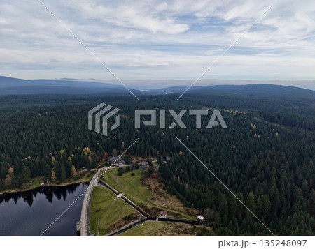vast water with trees and roads, gentle reflections of clouds on tranquil lake surrounded by hills vast water with trees and roads, gentle reflections of clouds on tranquil lake surrounded by hills 135248097