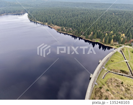 serene waterside path with trees, peaceful lakeside promenade featuring calming water and lush trees 135248103