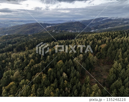 Sweeping Aerial Perspective Of Mountain Woodland With Layered Ridges And Atmospheric Clouds Sweeping Aerial Perspective Of Mountain Woodland With Layered Ridges And Atmospheric Clouds 135248228