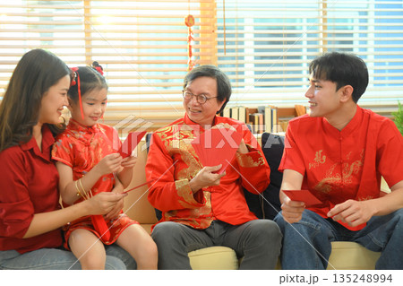 Asian grandparents giving red envelope to descendants during Chinese New Year family reunion 135248994