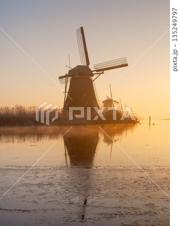 Traditional Dutch landscape with warm sun light, water reflections, and calm morning atmosphere. Traditional Dutch landscape with warm sun light, water reflections, and calm morning atmosphere. 135249797