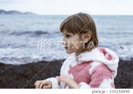 little cute blond girl curious smiling playing outside on sea, lifestyle people concept 135250840