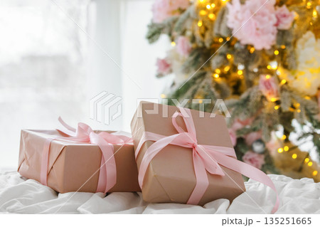 Soft pink Christmas gift boxes with ribbon on blurred holiday festive lights bokeh background 135251665