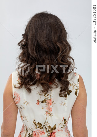 Studio shot of woman showcasing casual floral attire and relaxed demeanor, Portrait of female model with loose dark curls and timeless fashion style in bright studio setting Studio shot of woman showcasing casual floral attire and relaxed demeanor, Portrait of female model with loose dark curls and timeless fashion style in bright studio setting 135251681