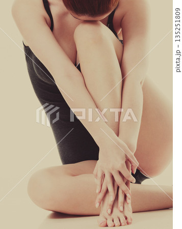 Sitting woman in underwear showing smooth legs Sitting woman in underwear showing smooth legs 135251809