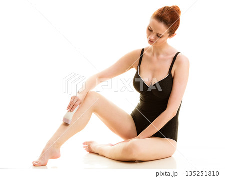 Woman shaving her legs with electric razor Woman shaving her legs with electric razor 135251810