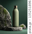 Eco-friendly green water bottle displayed on stone pedestal with textured rocks in background 135251896
