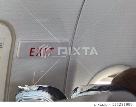 Airplane exit sign. Safety, navigation, and emergency direction inside passenger aircraft. 135251999