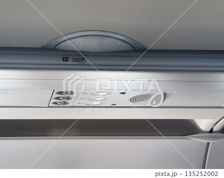 Airplane overhead compartments and ceiling. Aviation design, passenger service, and storage inside cabin. 135252002